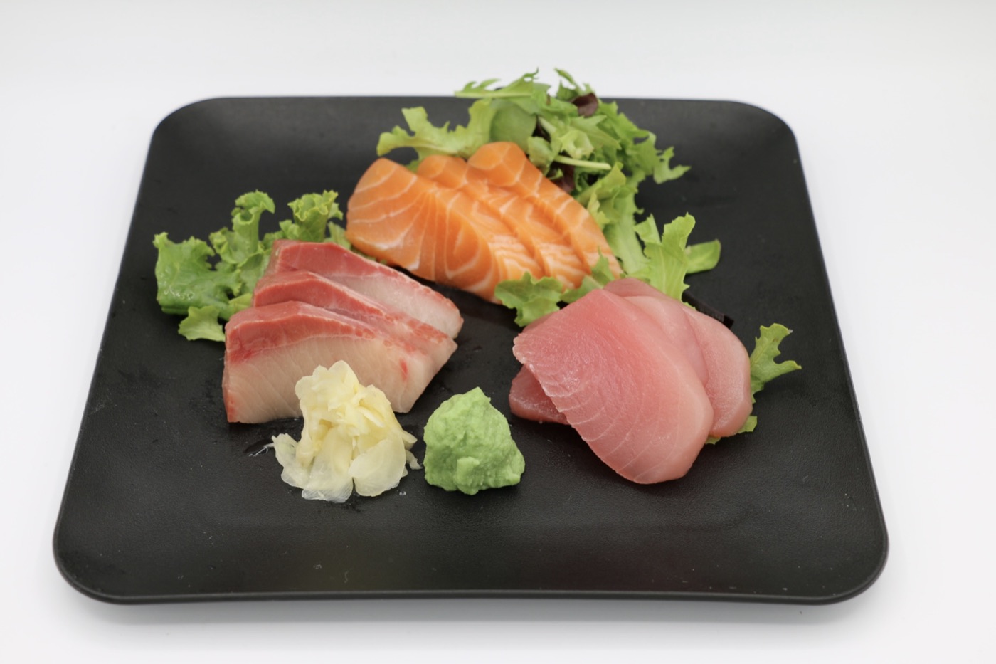 Sashimi combo plate with slices of salmon, tuna, and yellowtail